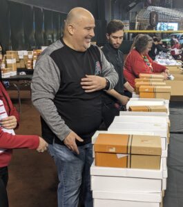 Leo Gilmartin and other volunteers handing out shoes to children.