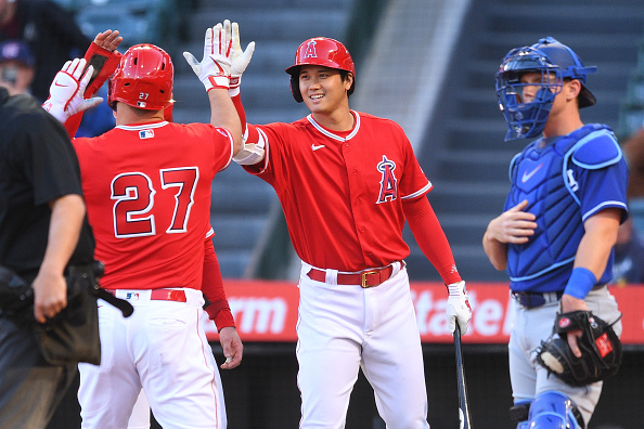 Shohei Ohtani hi-fives teammate Mike Trout. Both are members of the 2023 Los Angeles Angels.