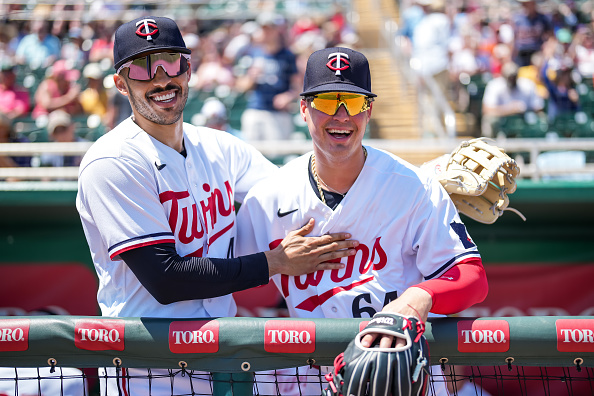Carlos Correa and Jose Miranda of the 2023 Minnesota Twins smile in the dugout