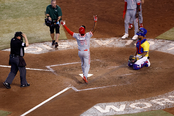 Otto Lopez touches home after hitting a home run for Canada versus Colombia