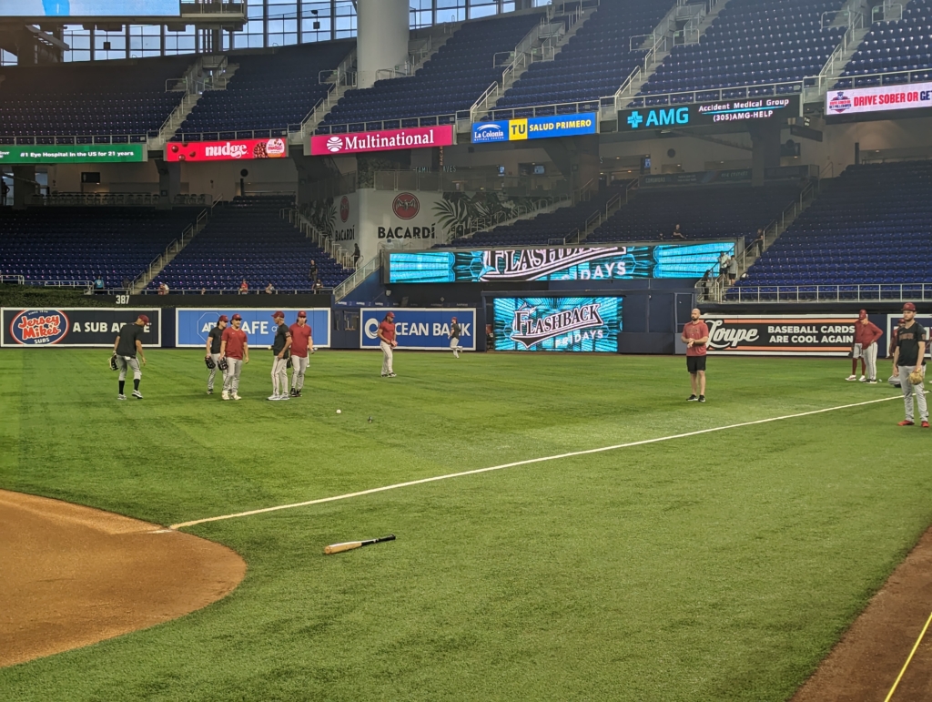 Diamondbacks outfielders speaking with the outfield coach during pregame warmups against the Marlins