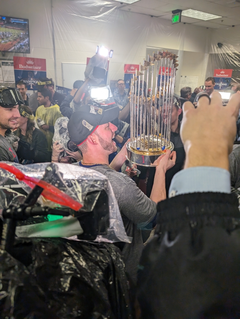 The Rangers celebrating with the Commissioner's Trophy after their World Series victory over the Diamondbacks
