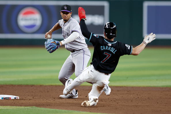 Ezequiel Tovar of the Rockies turning a double play against the Diamondbacks