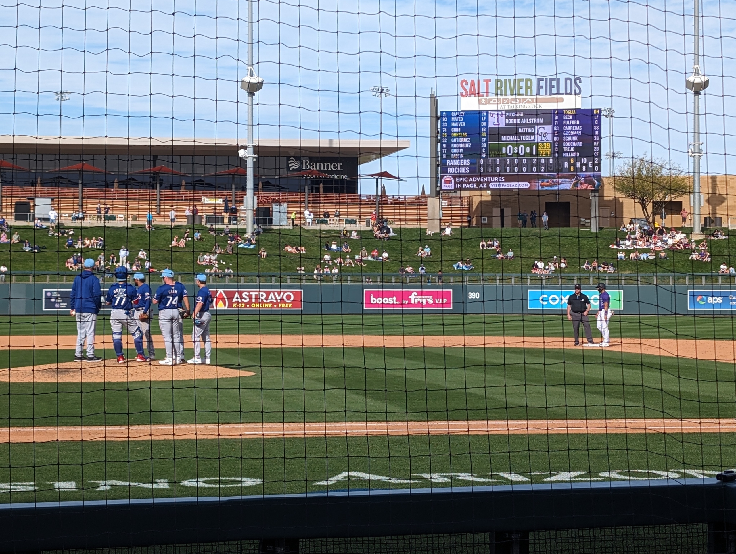 The Texas Rangers meet on the mound during a pitching change against the Colorado Rockies.