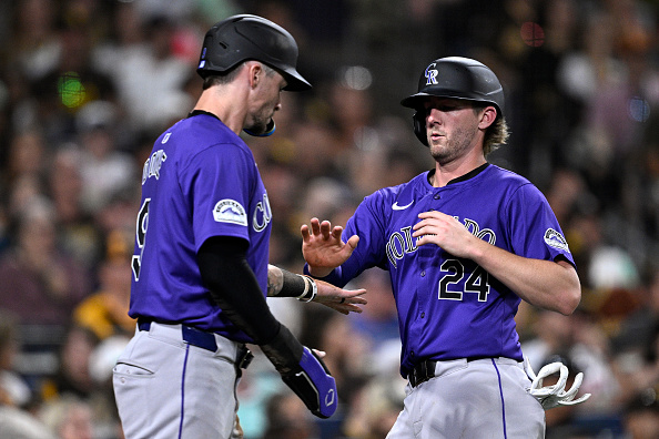 Brenton Doyle and Ryan McMahon of the Rockies celebrate a two-run single by Kris Bryant against the Padres