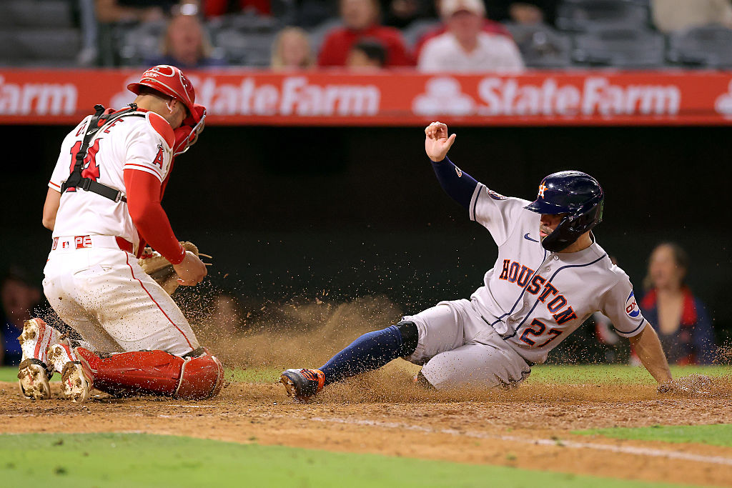 Jose Altuve of the Astros sliding home safely against the Angels