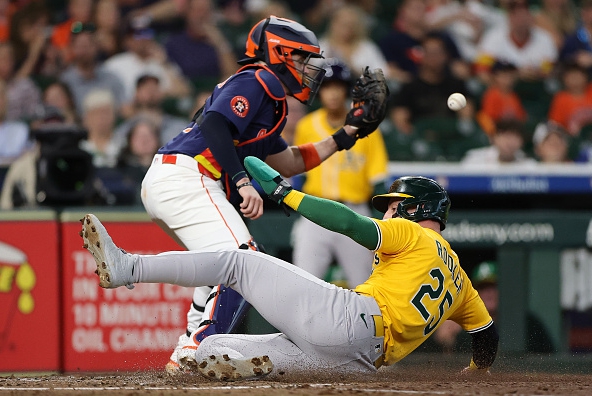 Brent Rooker of the Athletics slides home safely against the Astros
