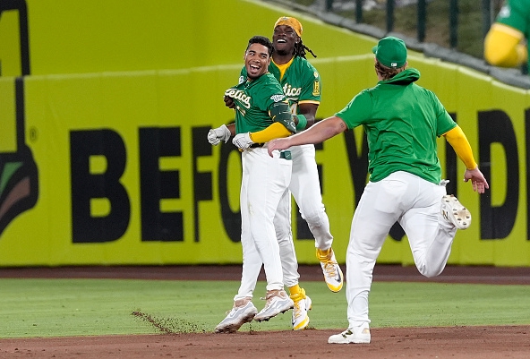 Darell Hernaiz and the Athletics celebrating a 10th-inning win over the Tigers
