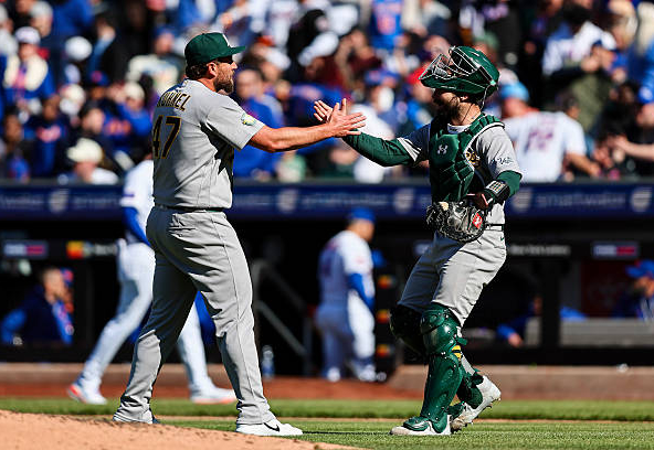 Joel Kuhnel and Shea Langeliers of the Athletics celebrating a win and sweep over the Mets
