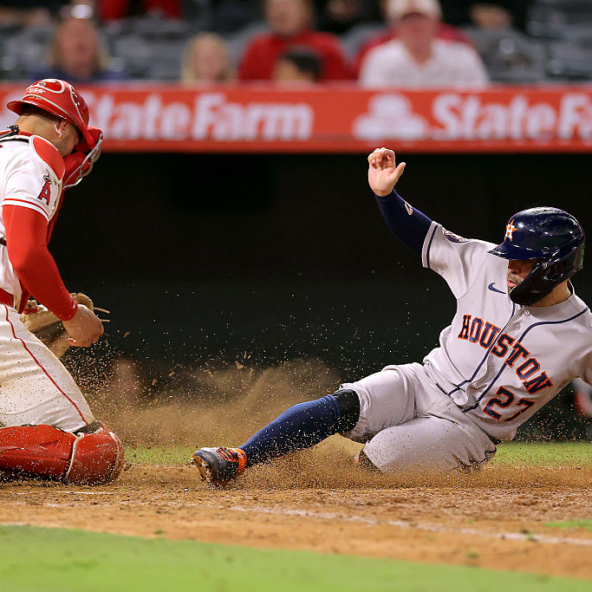 Jose Altuve of the Astros sliding home safely against the Angels