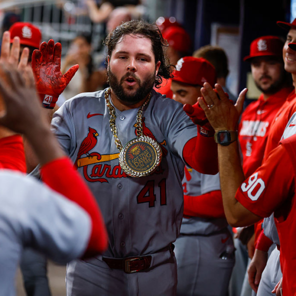Alec Burleson of the Cardinals celebrating a home run against the Braves with his teammates