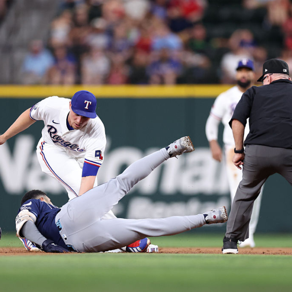 Corey Seager of the Rangers tagging out Victor Mesa Jr. of the Rays