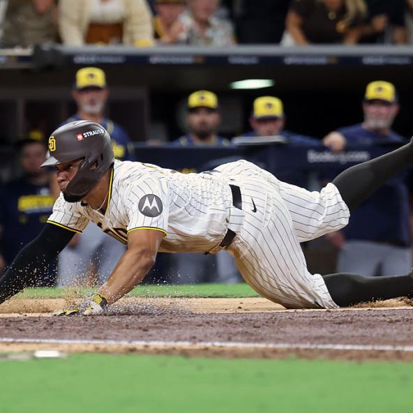 Xander Bogaerts of the Padres diving into home to score a run in Game Three of the 2026 NLDS against the Brewers