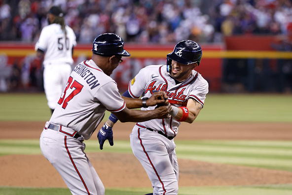 Eddie Rosario celebrates with Braves third-base coach Ron Washington after hitting a ninth-inning grand slam against the Diamondbacks.