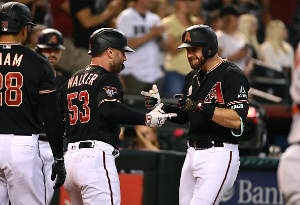 Christian Walker of the Diamondbacks celebrates his home run against the Orioles with his teammate, Evan Longoria