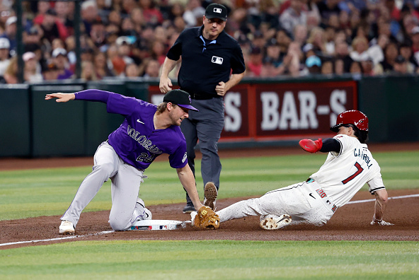 Ryan McMahon tagging out Corbin Carroll at third on a steal attempt, his knee atop the bag. Infielders are adopting this positioning to avoid obstruction.